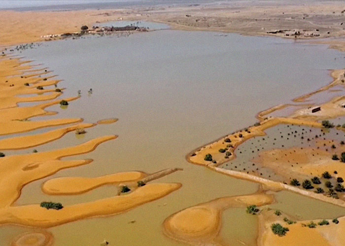 Aerial view of a desert oasis with sandy patterns and water, capturing interesting geographical facts simplified for kids.