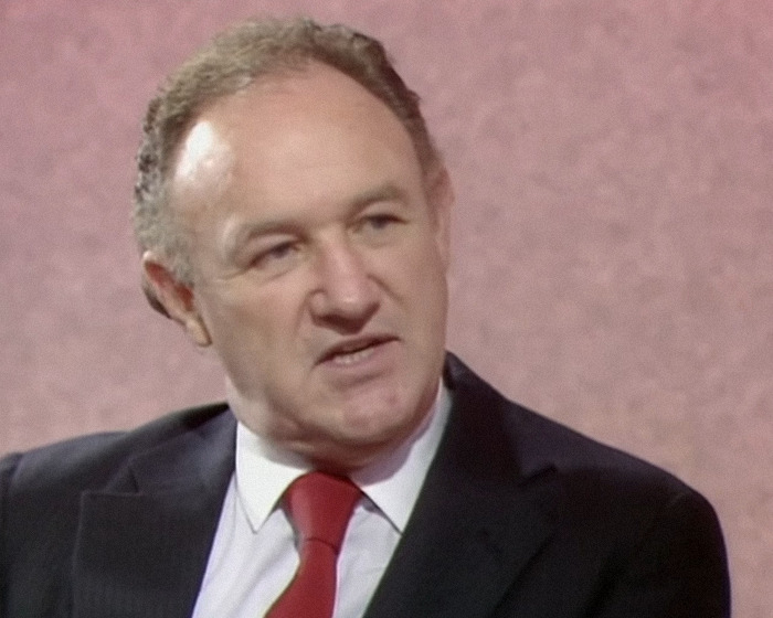 Gene Hackman wearing a suit during an interview.