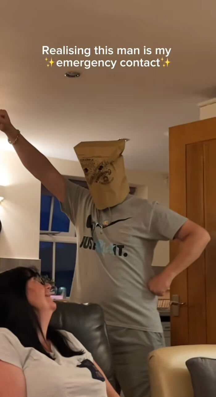 Man with a paper bag on his head playfully posing, woman laughing; the real crisis in handling emergencies.