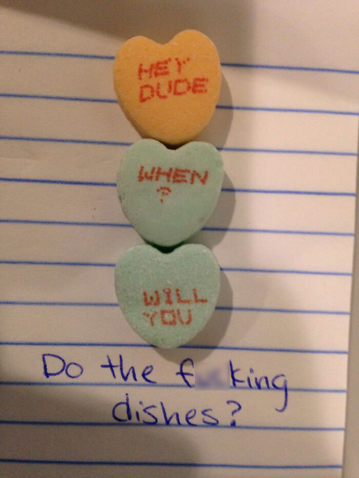 Valentine's candy hearts with playful messages on a notebook page.