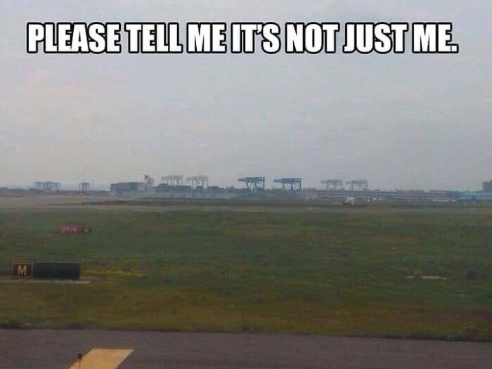 A field with distant machinery resembling Star Wars AT-ATs, featuring the meme text "PLEASE TELL ME IT'S NOT JUST ME".