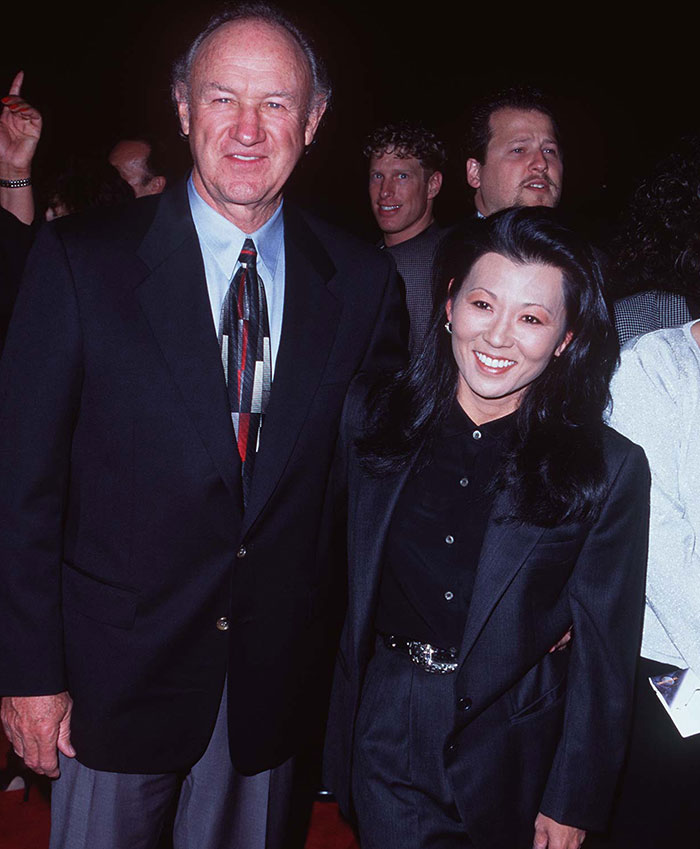 Elderly couple smiling together at an event, both dressed in formal attire.