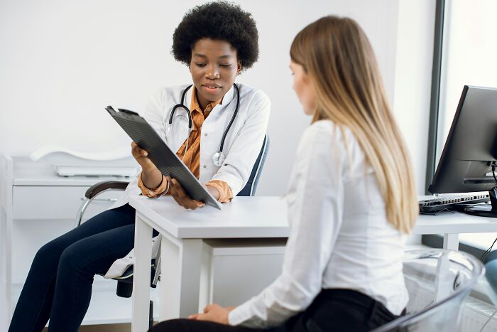 Doctor discussing health challenges of adulthood with a patient in an office setting.