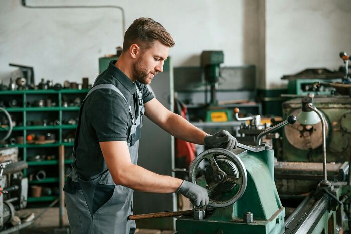A factory worker operating machinery, representing professions employing millions potentially becoming useless.