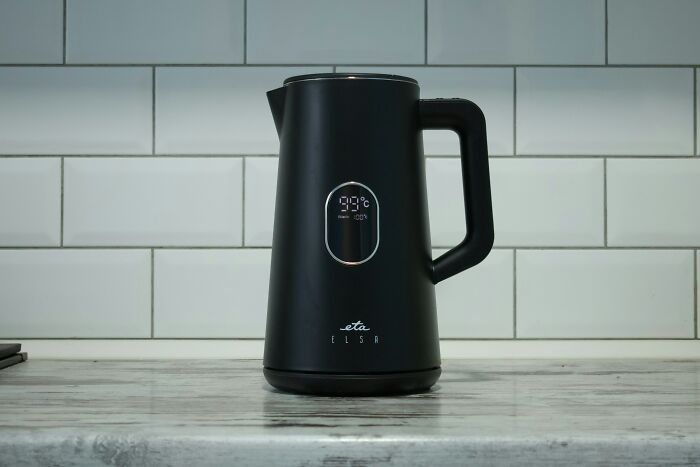 Multi-functional electric kettle on a kitchen counter with a tiled backsplash.