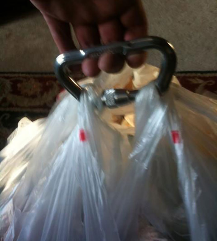 Carabiner used to carry multiple grocery bags, showcasing a helpful grocery-shopping hack for easier handling.