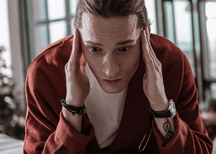 Man looking stressed, wearing a red sweater, highlighting family conflict and entitlement issues. Man looking stressed, wearing a red sweater, highlighting family conflict and entitlement issues.