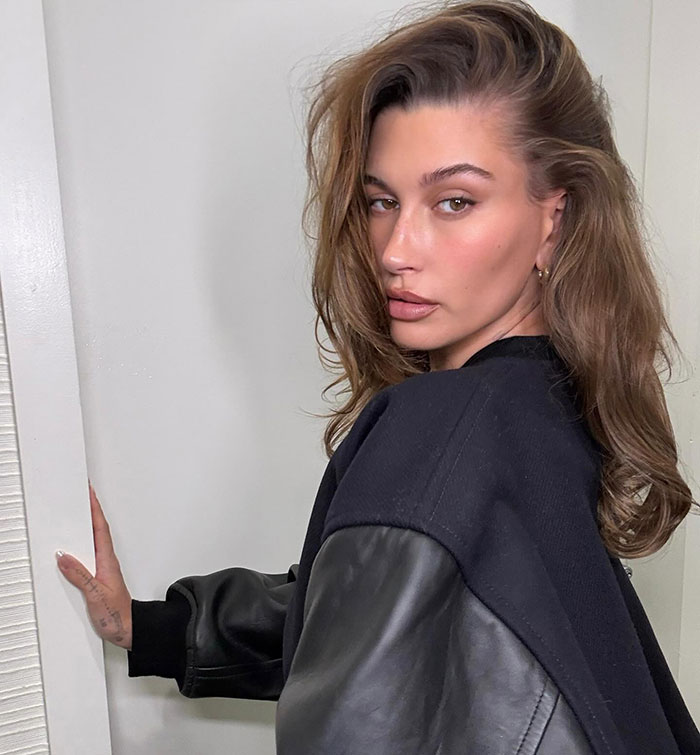 A woman in a black jacket posing indoors. A woman in a black jacket posing indoors.