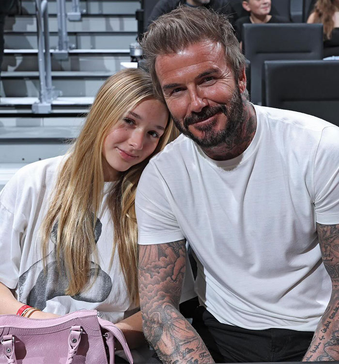 Father and daughter sitting together, smiling at a sports event. Father and daughter sitting together, smiling at a sports event.
