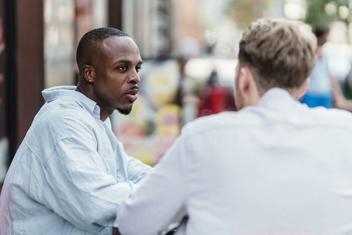 Two friends sitting outside, having a serious conversation about a house leech issue.