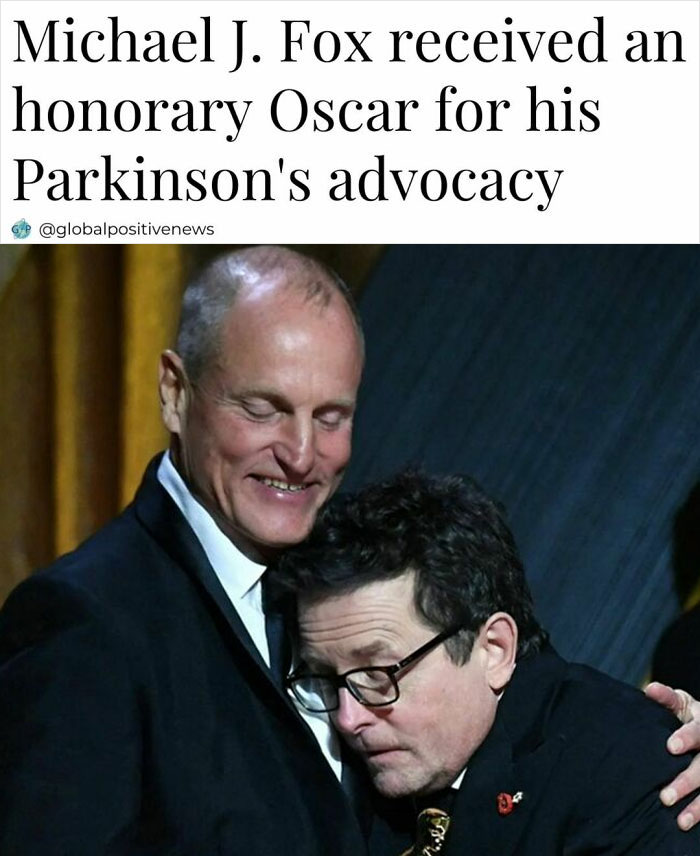 Two men embracing on stage, celebrating an honorary Oscar for advocacy, exemplifying restored faith in humanity.