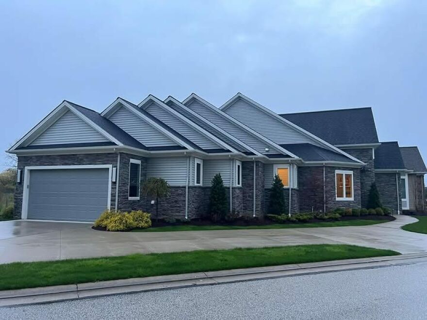 Unusual house design with multiple gabled roofs viewed from the street, showcasing architecture shaming appeal.
