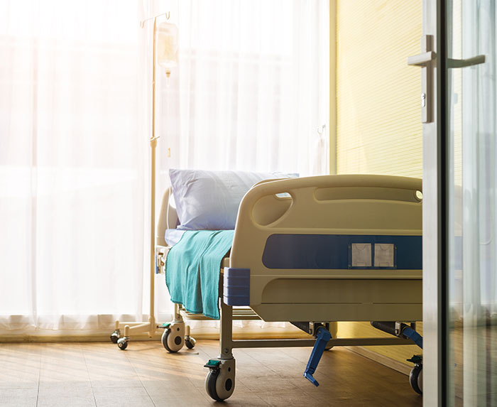 Hospital room with empty bed and IV stand, related to unknown illness outbreak. Hospital room with empty bed and IV stand, related to unknown illness outbreak.