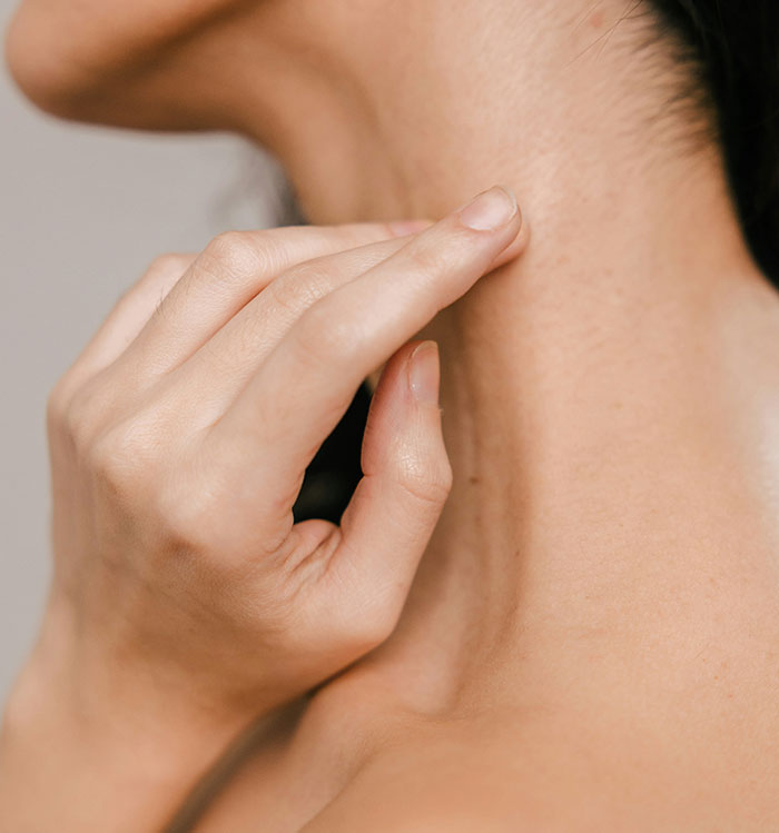 Close-up of a hand gently touching a neck, representing fantasy romance book tropes.