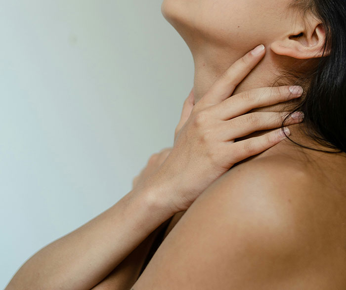 Close-up of a person with hands on neck, reflecting common fantasy romance tropes.