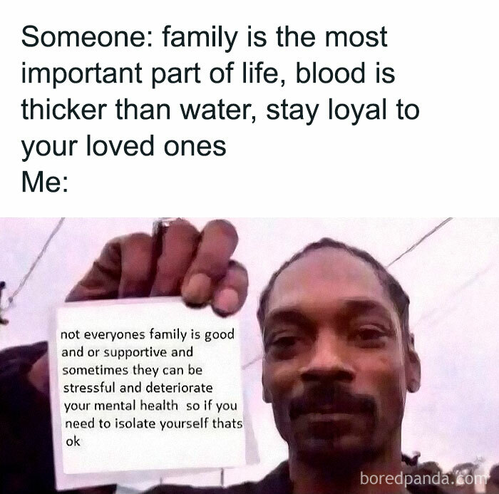 Person holding a sign about family and mental health, countering the idea that family always supports well-being.