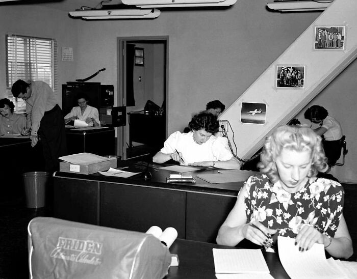 Black and white photo of office workers in a bygone era, illustrating jobs that faded as society evolved.