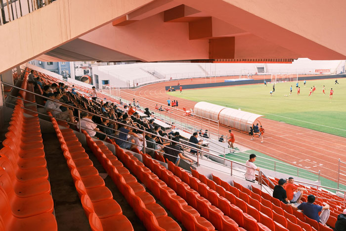 Stadium seats overlooking a football game, highlighting support for a football hobby.
