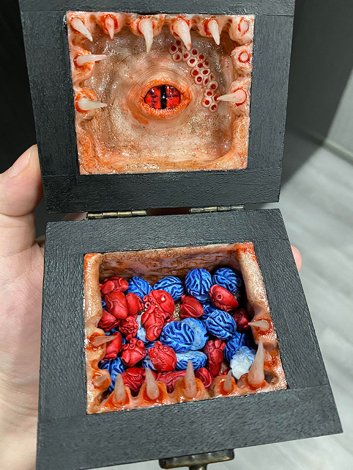 Creepy handmade craft box with a red eye, teeth, and colorful brains inside.