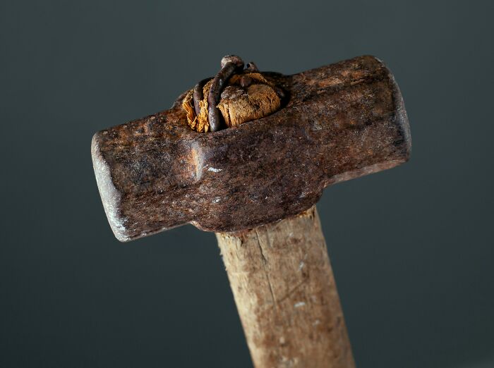 A rusty hammer with a wooden handle, highlighting goods to buy before tariffs increase.