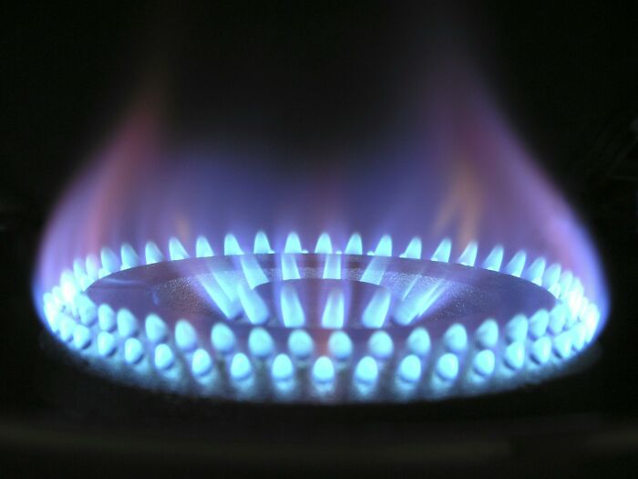 Blue flames on a gas stove burner, representing bizarre facts about energy use discussed online.