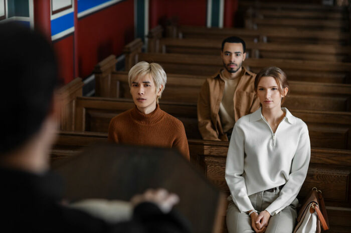 Three people sitting in a courtroom, attentive to someone speaking, capturing the essence of bizarre facts in a serious setting.
