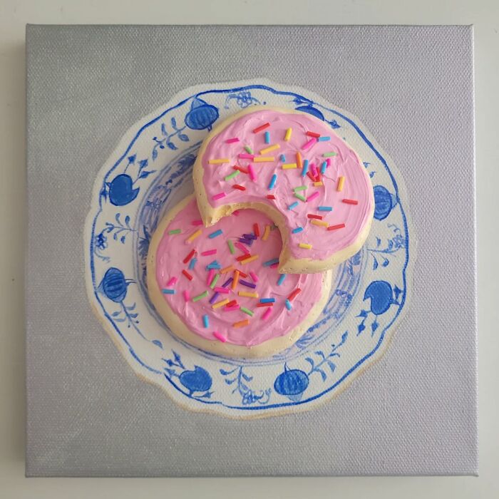 Hyper-realistic embroidered dessert art depicting cookies with pink icing and sprinkles on a decorative plate.