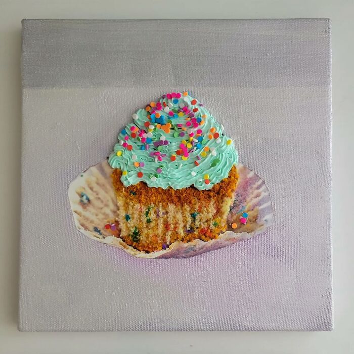 Hyper-realistic embroidered dessert cupcake with colorful frosting and sprinkles on a textured canvas background.