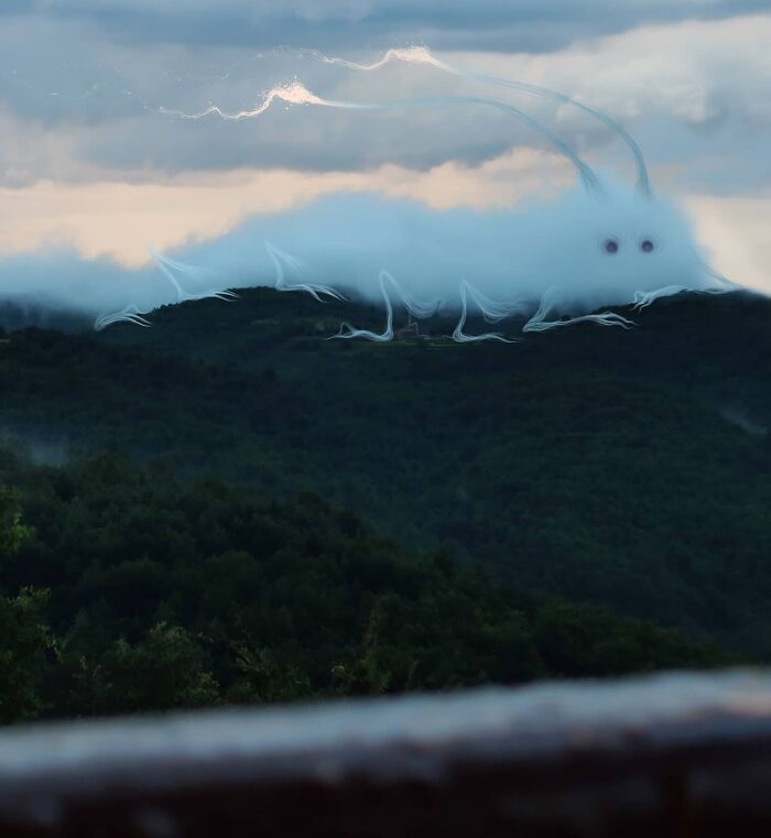 A fluffy creature resembling a cloud hovers over a lush forest landscape by Vorja Sánchez's "Interventions."