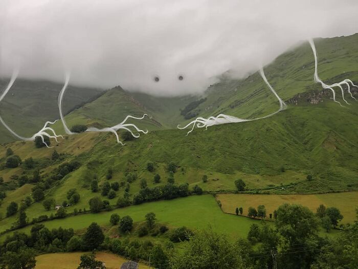 Cloud creature art emerging from the landscape, featuring whimsical lines and eyes, by Vorja Sánchez representing interventions.