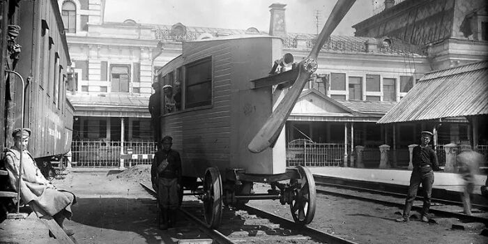 Vintage rail vehicle with propeller, highlighting an inventor's creation at a historic train station.