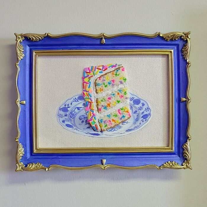 Hyper-realistic embroidered cake slice with colorful sprinkles, framed in blue and gold.