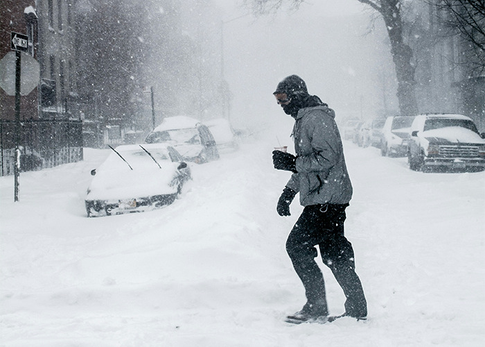 Person walking carefully through heavy snowstorm wearing winter clothing, illustrating essential life skills for difficult situations.