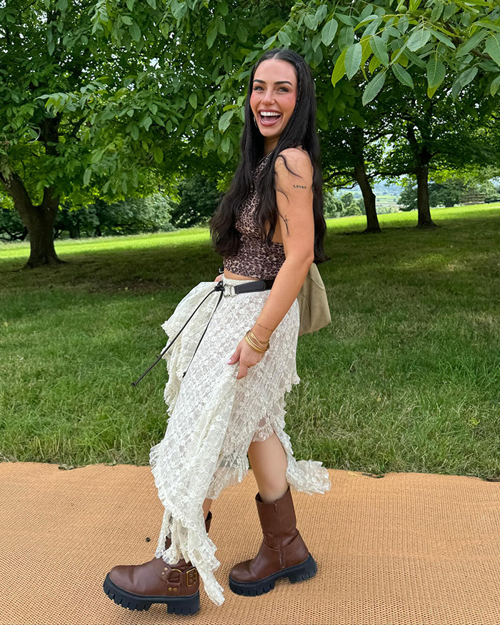 Influencer in a wetlook dress with lace detail, brown boots, posing outdoors amongst trees. Influencer in a wetlook dress with lace detail, brown boots, posing outdoors amongst trees.
