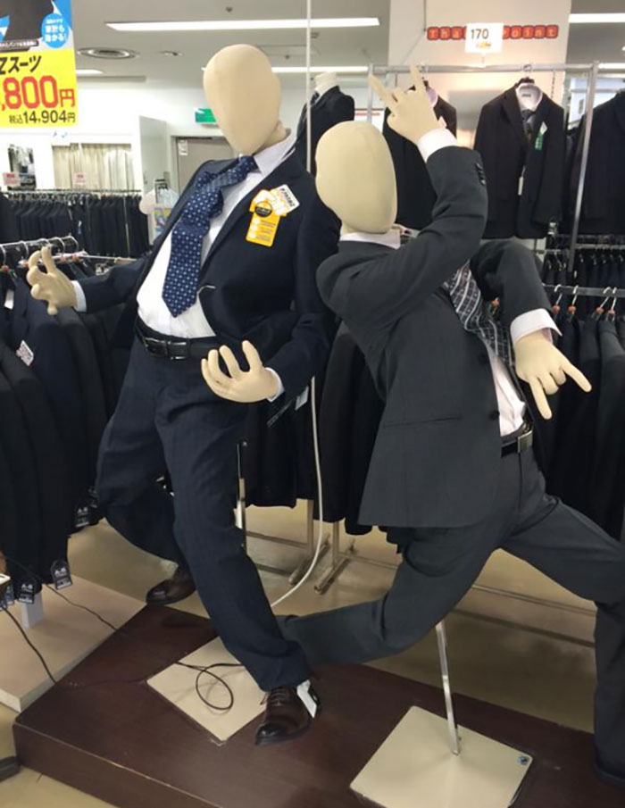 Mannequins in humorous poses wearing suits in a Japanese store, showcasing interesting Japan pics.