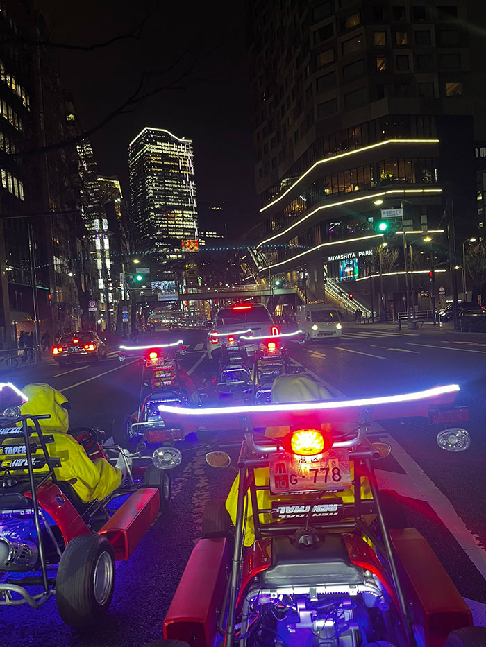 Go-karts on a bustling Tokyo street at night, showcasing vibrant Japan cityscape.