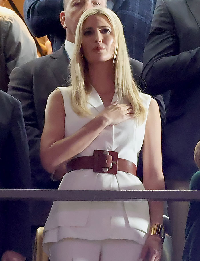 A person in a white outfit and brown belt at Super Bowl 2025.
