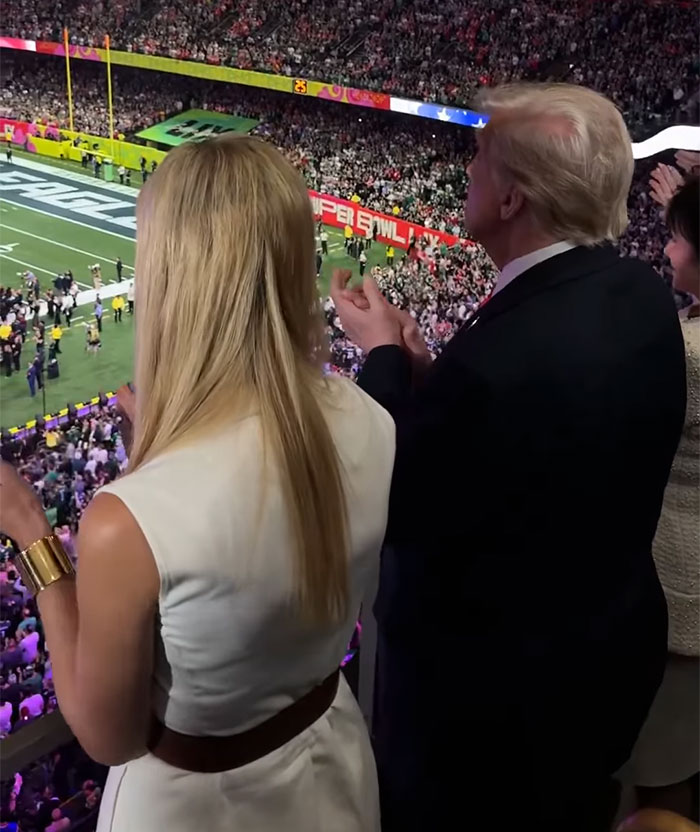 Spectators at a Super Bowl event, with focus on hair extensions style from behind.