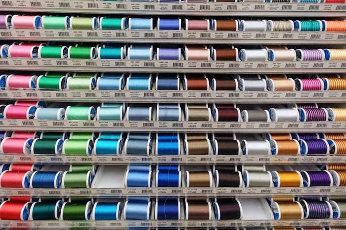 Colorful sewing thread spools on display at a Joann fabric and craft retailer.