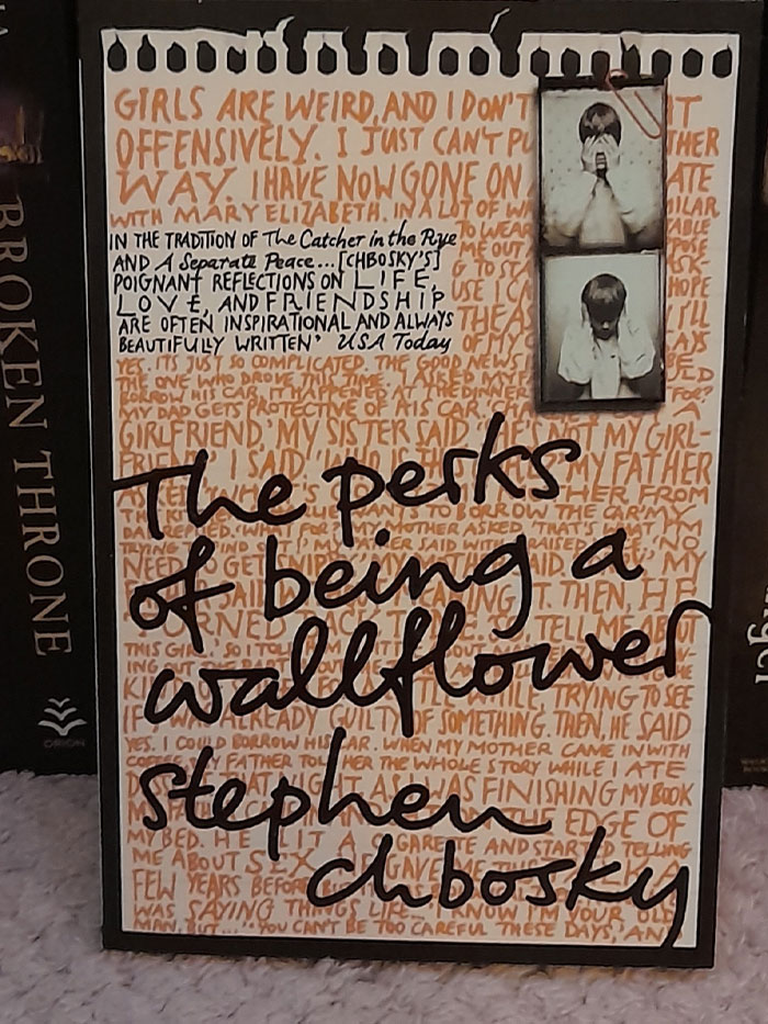"The Perks of Being a Wallflower book cover featuring quotes as background text."