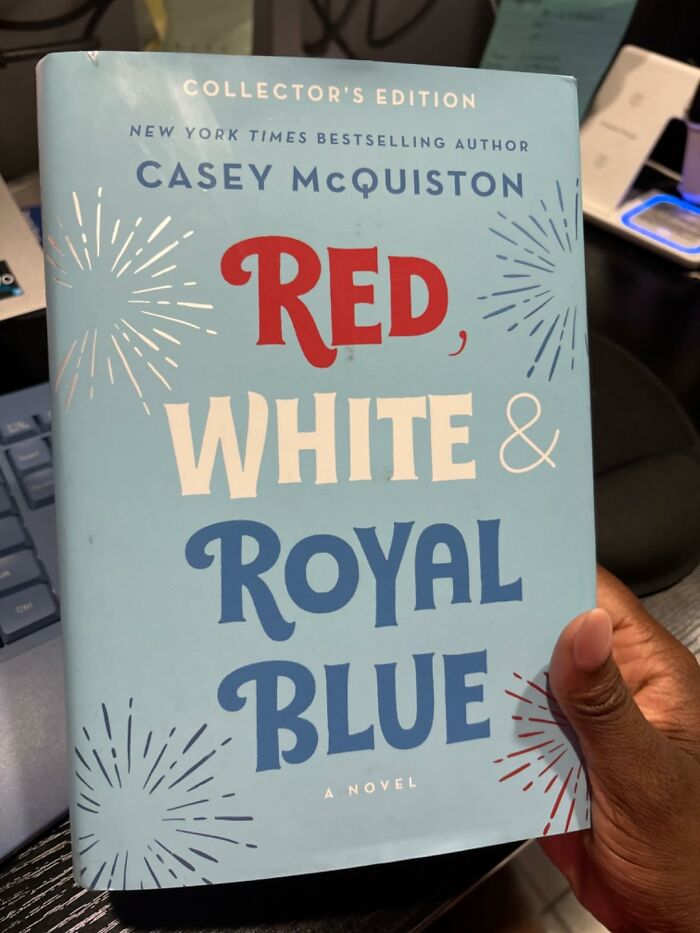 A person holding a collector's edition of "Red, White & Royal Blue," a novel with notable book quotes.