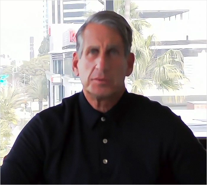 Man in a black shirt sitting indoors, related to Blake Lively and Ryan Reynolds lawyer controversy. Man in a black shirt sitting indoors, related to Blake Lively and Ryan Reynolds lawyer controversy.