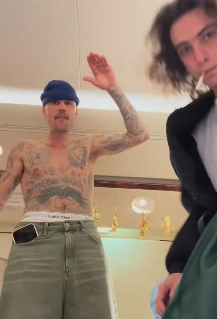 Tattooed man in green pants and beanie stands with a blurred background, emphasizing "new daddy" concerns.