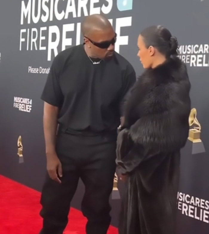 Bianca Censori and Kanye West dressed for the red carpet at a music event, engaged in conversation.