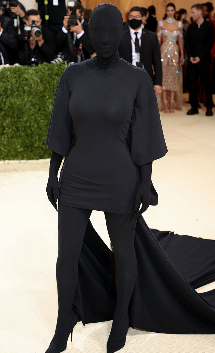 Celebrity in full-body black outfit at a public event, capturing attention with a unique and unconventional fashion choice.