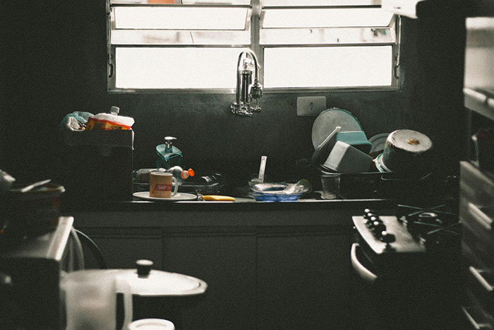 Cluttered kitchen sink with dirty dishes, highlighting neglecting chores and household responsibilities.