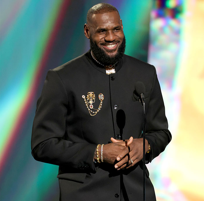Man in formal black attire smiling at the Met Gala, amid discussions on the event's dress code and celebrity hosts. Man in formal black attire smiling at the Met Gala, amid discussions on the event's dress code and celebrity hosts.