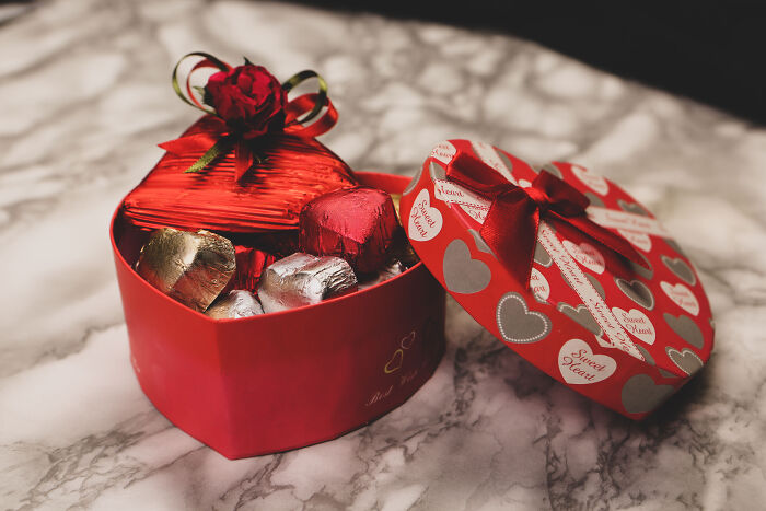 Heart-shaped Valentine’s gift box with chocolates and a red ribbon, perfect for meaningful occasions.