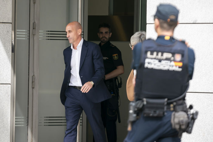 Former football head leaving a building, surrounded by police officers, after being fined &euro;10,000.