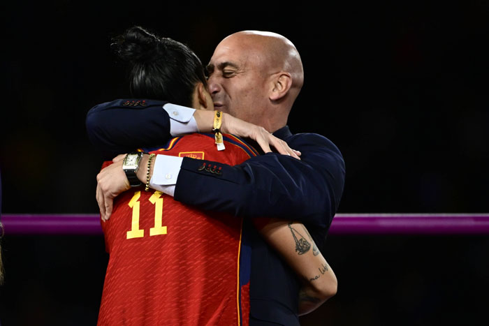 Luis Rubiales hugging Jenni Hermoso on a sports field.